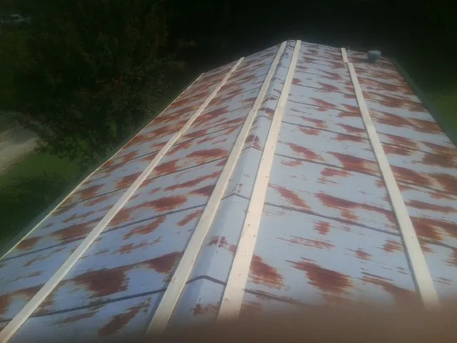 Rusted metal roof panels with new wood purlins before replacement — Storm Damage Roof Repair in Orrville by Roofing Brothers