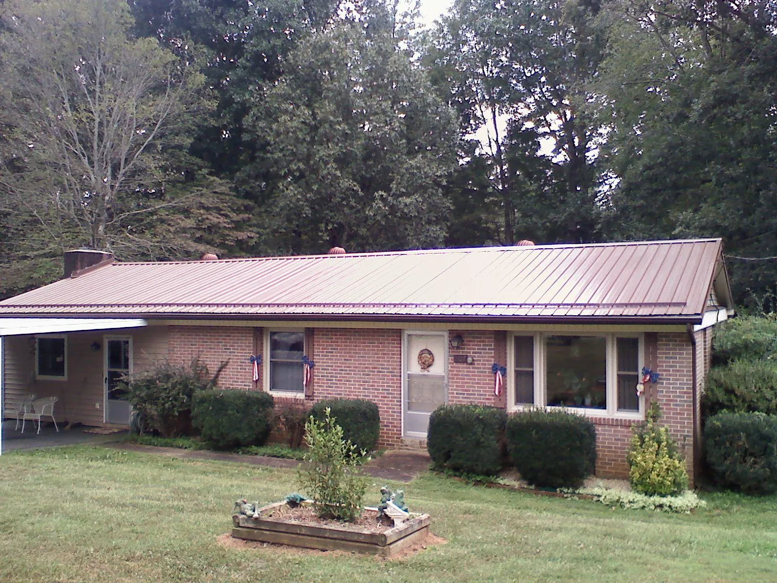 Bronze metal roof on a brick ranch home with a carport in Orrville