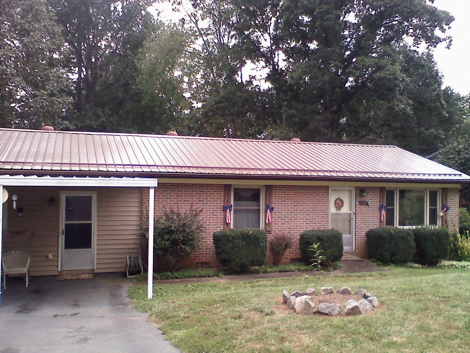 Bronze metal roof and carport on a brick ranch home — Roof Repair work by our crew in Orrville